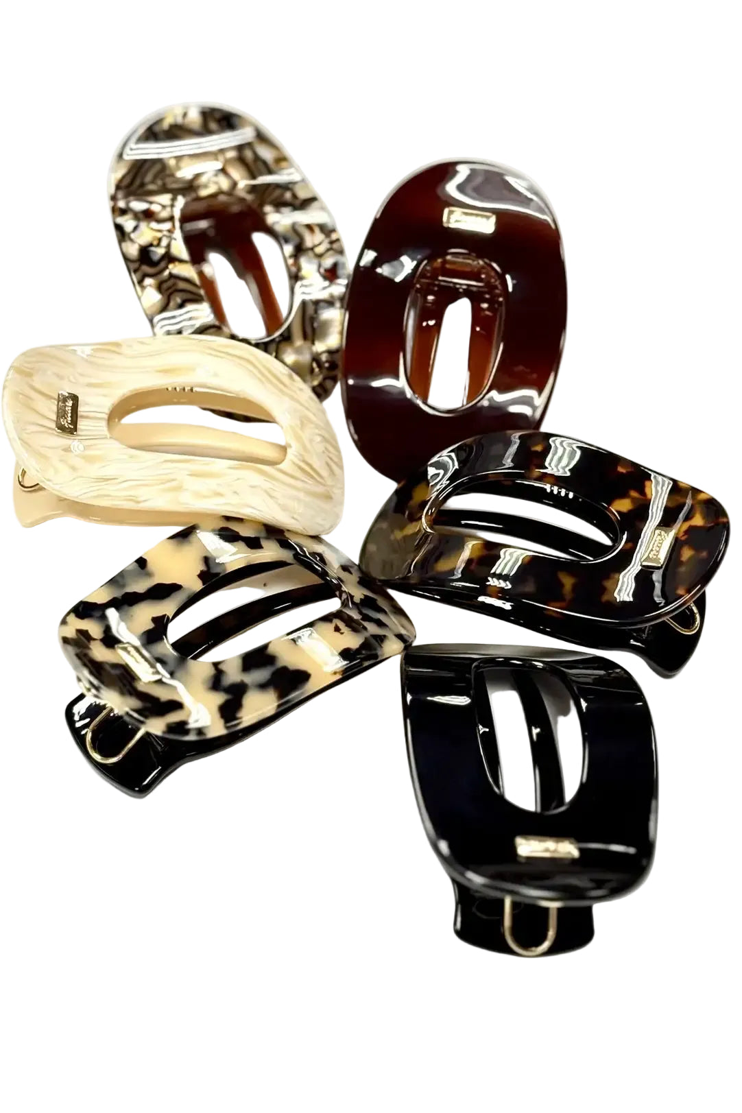 Six glossy hair flat back claw clips in various patterns and colors, including tortoiseshell, leopard print, and solid black and cream, arranged on a plain white background.