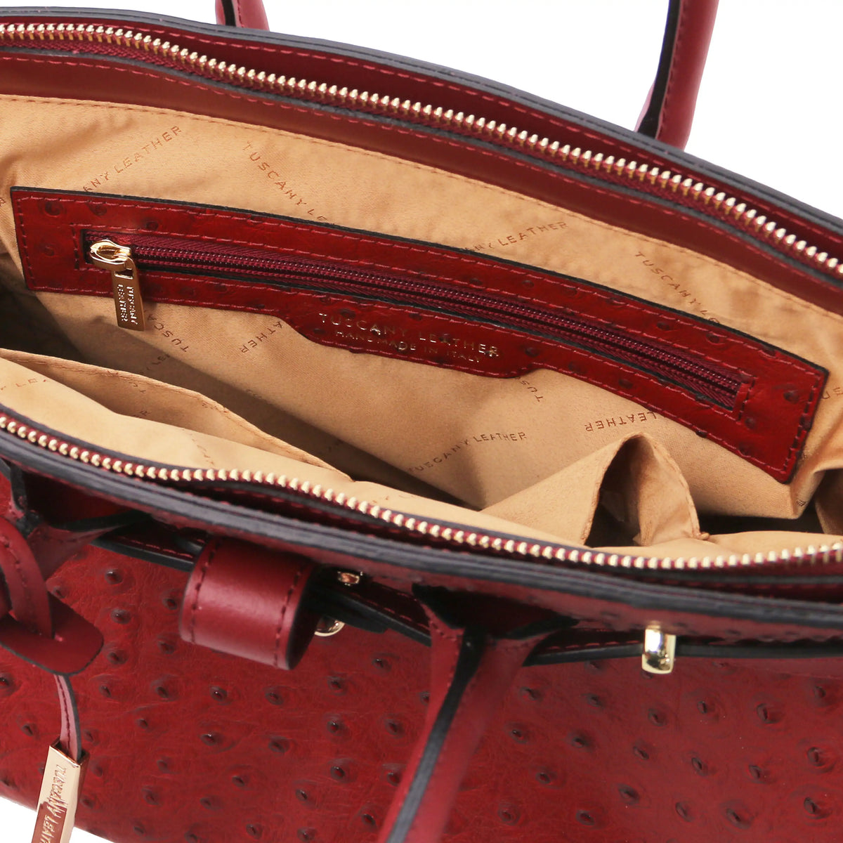 Red leather ostrich print handbag with interior zipper pocket and beige lining  on a white background