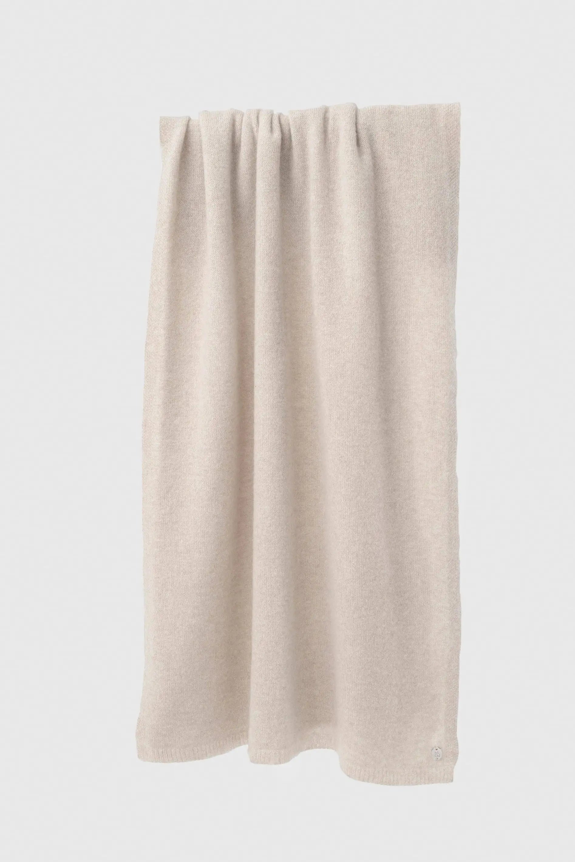 A light beige knit curtain panel with a gathered, pleated top edge, shown hanging against a plain white background.