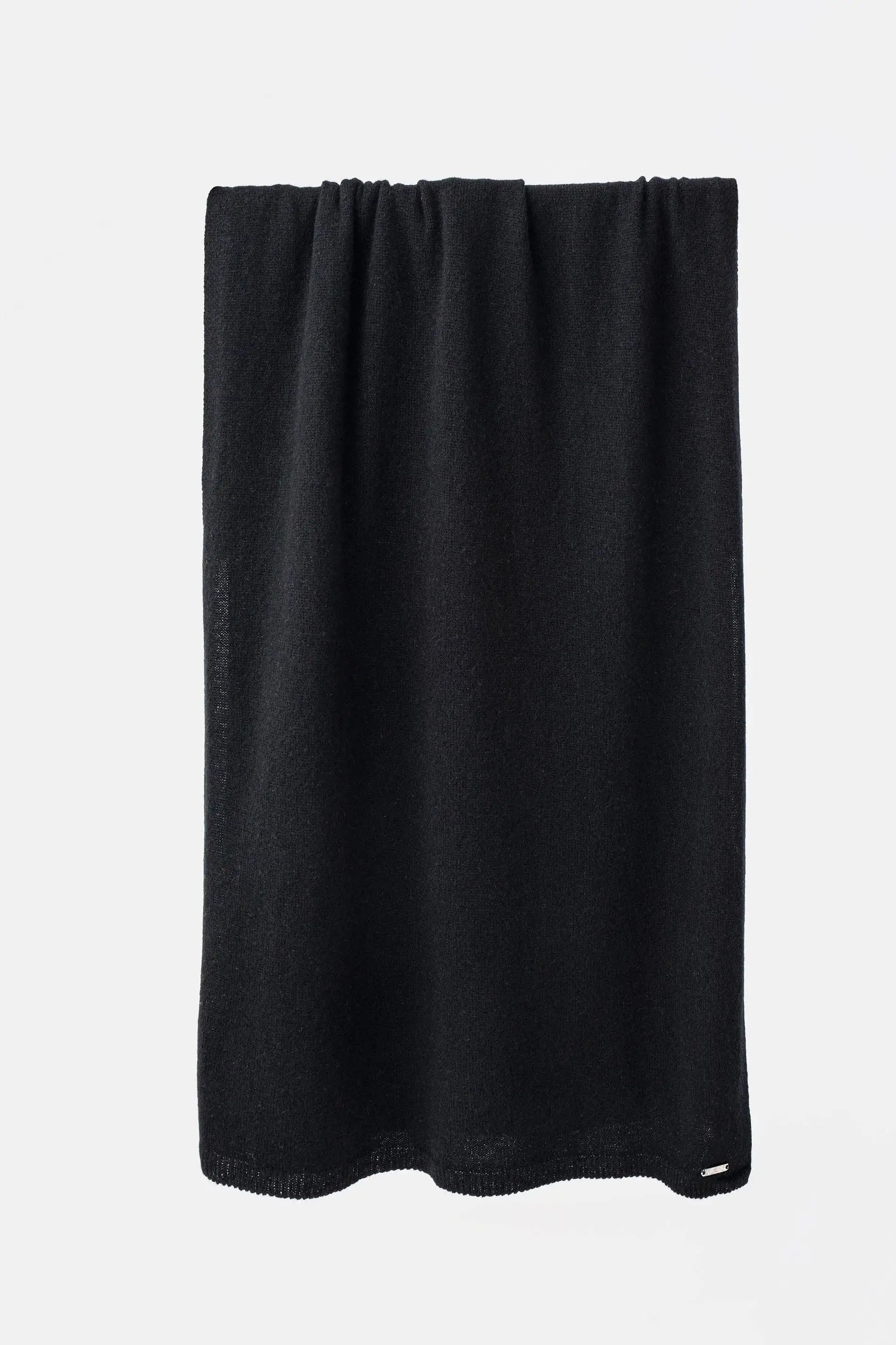 A black textured towel draped vertically against a clean white background.