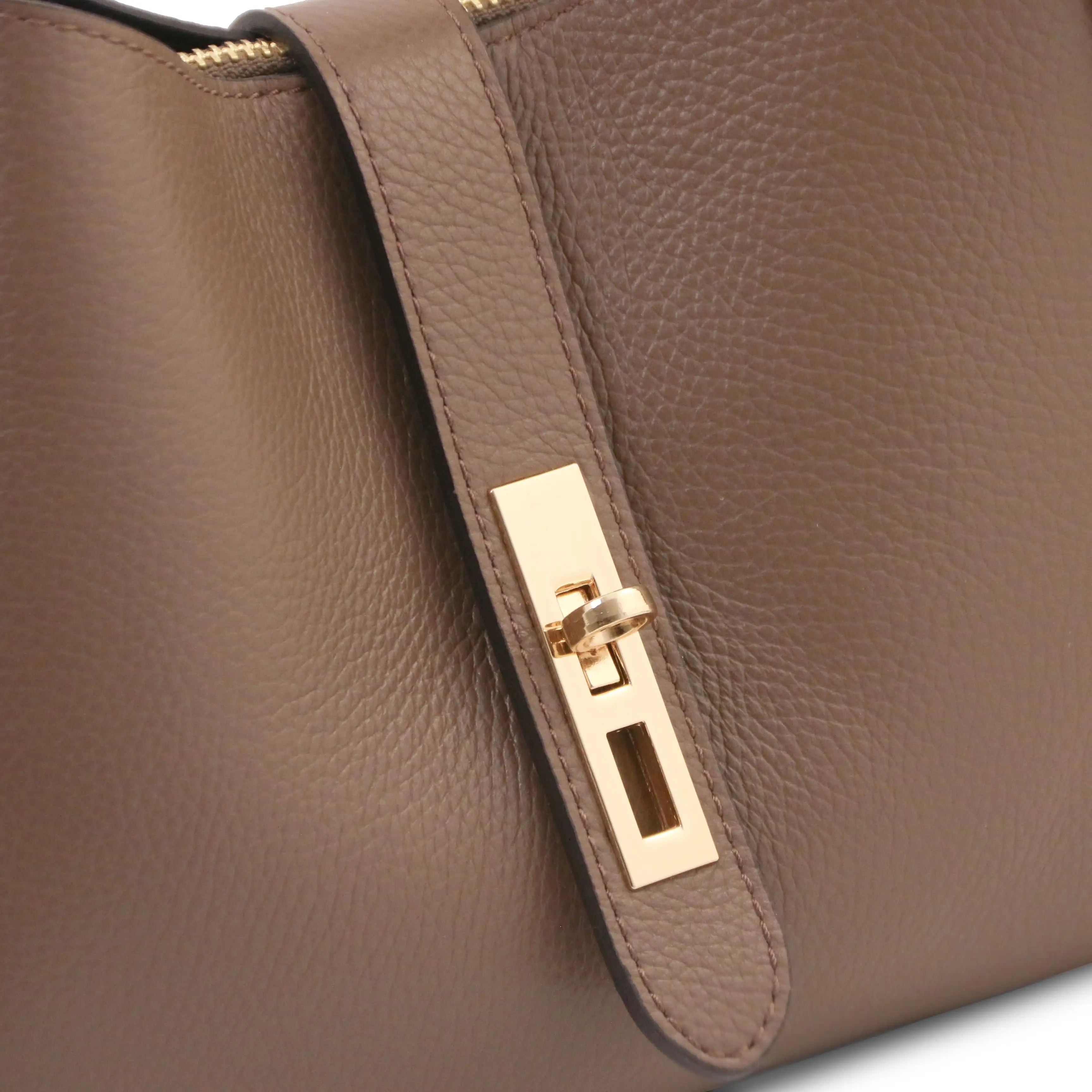 Close-up of a dark taupe pebbled leather handbag featuring a gold-tone metal turn-lock clasp on a matching leather strap.