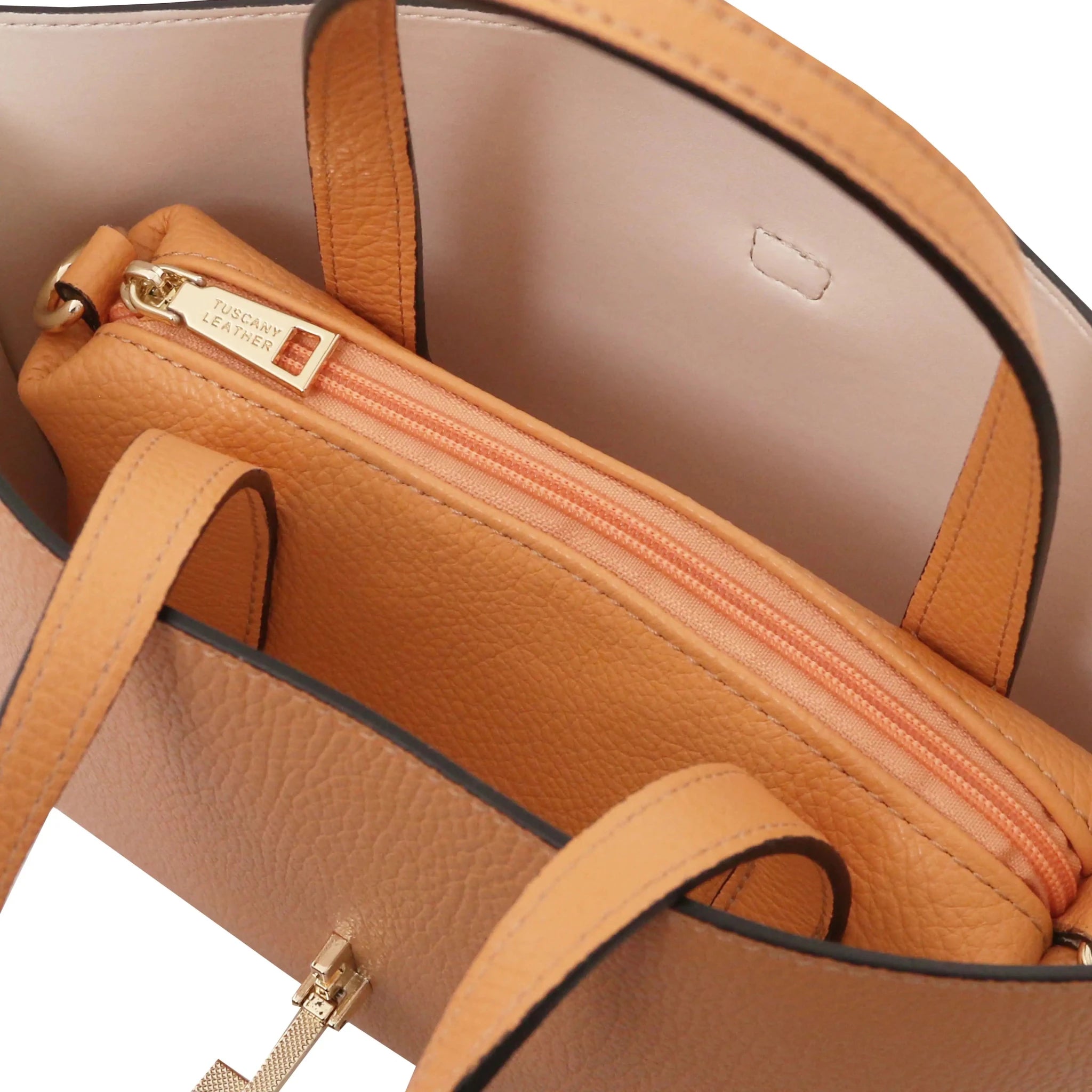 Apricot handbag with beige interior and central zippered compartment on a white background