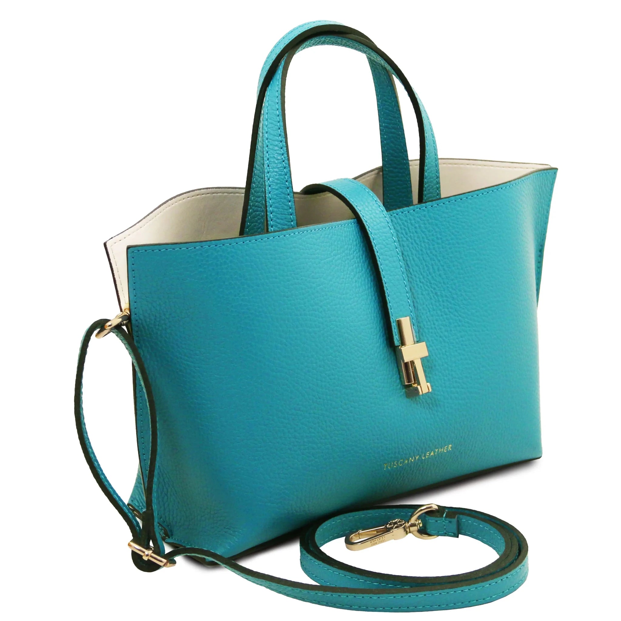 Turquoise handbag with gold accents, red interiorand detachable crossbody strap on a white background