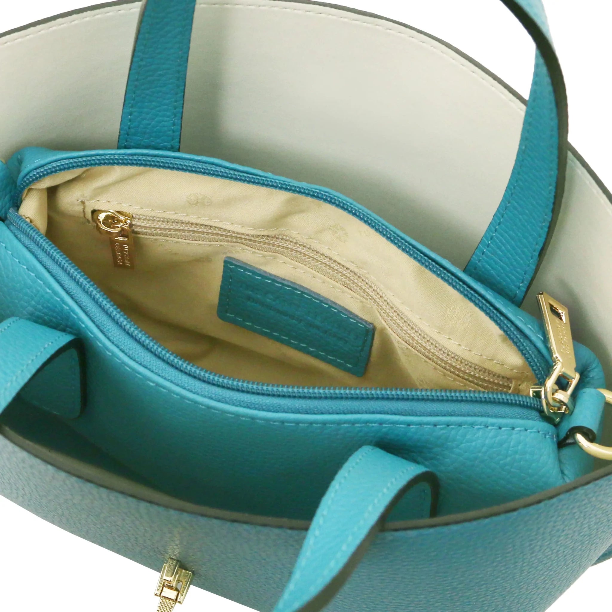 Close-up of a beige interior of turquoise bag with  zip pocket and stitching details.
