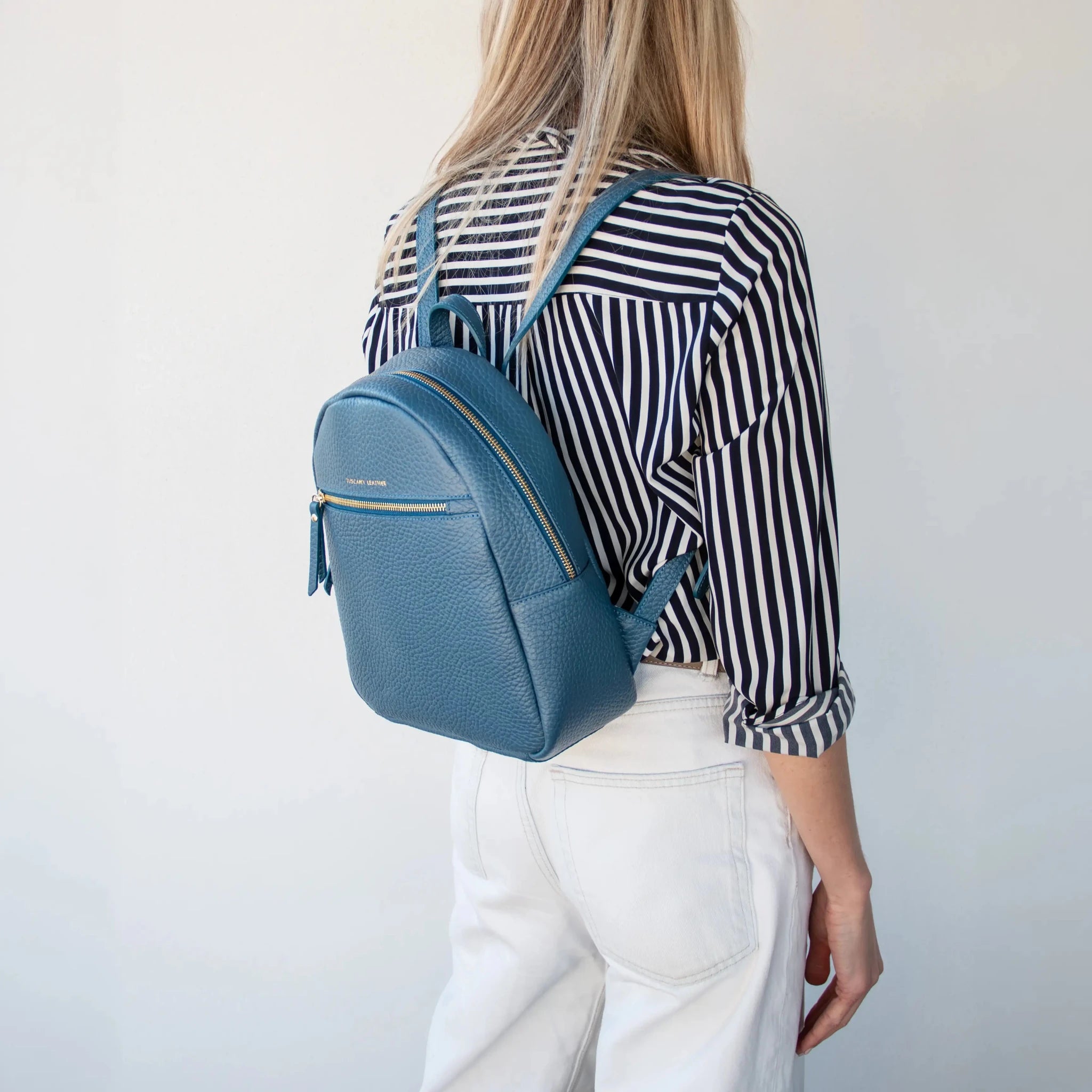 Woman carrying the Arco Italian Pebbled Leather Backpack in Denim