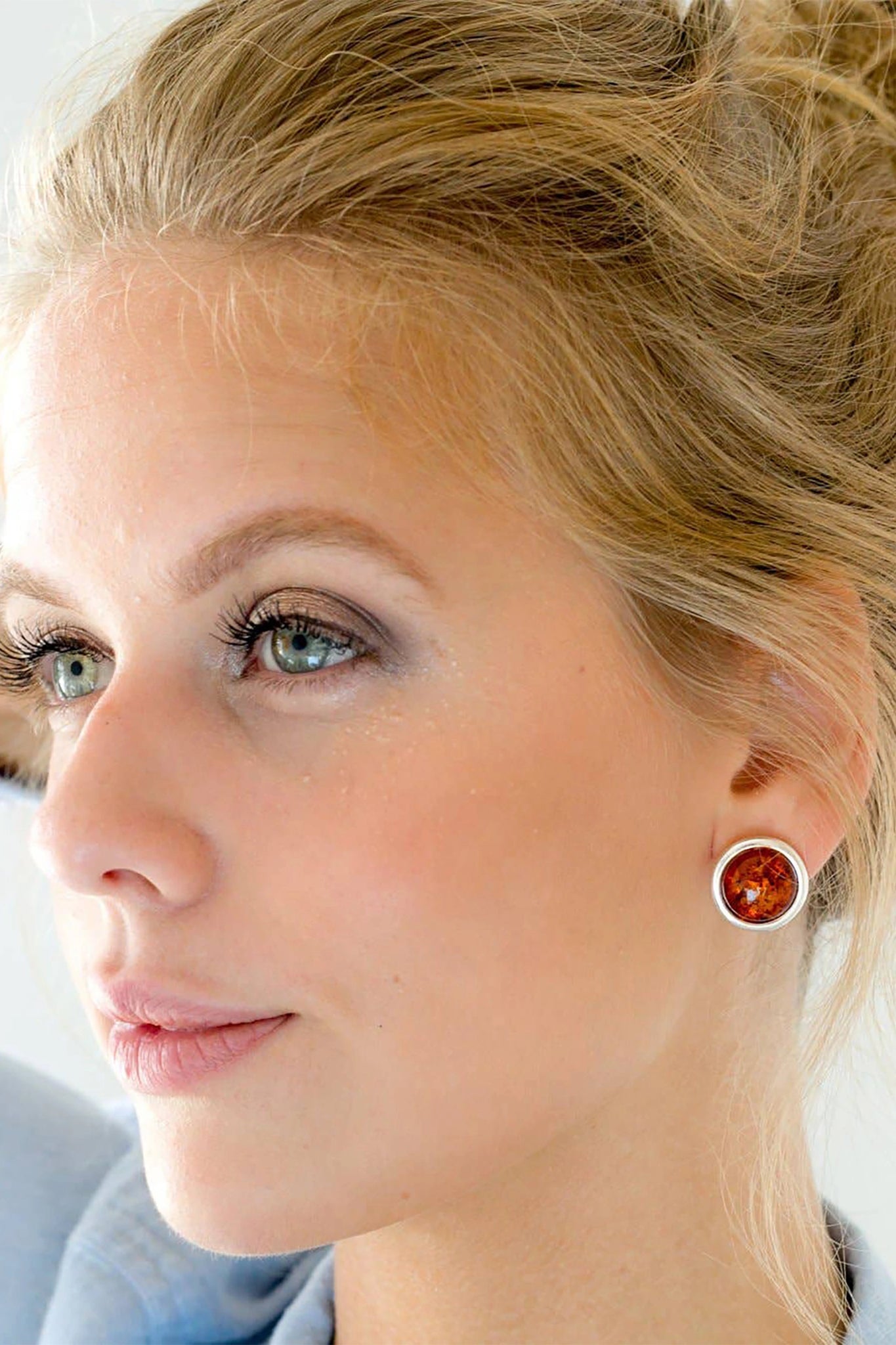 A model is wearing the Baltic Honey Amber Statement Round Stud Earrings 