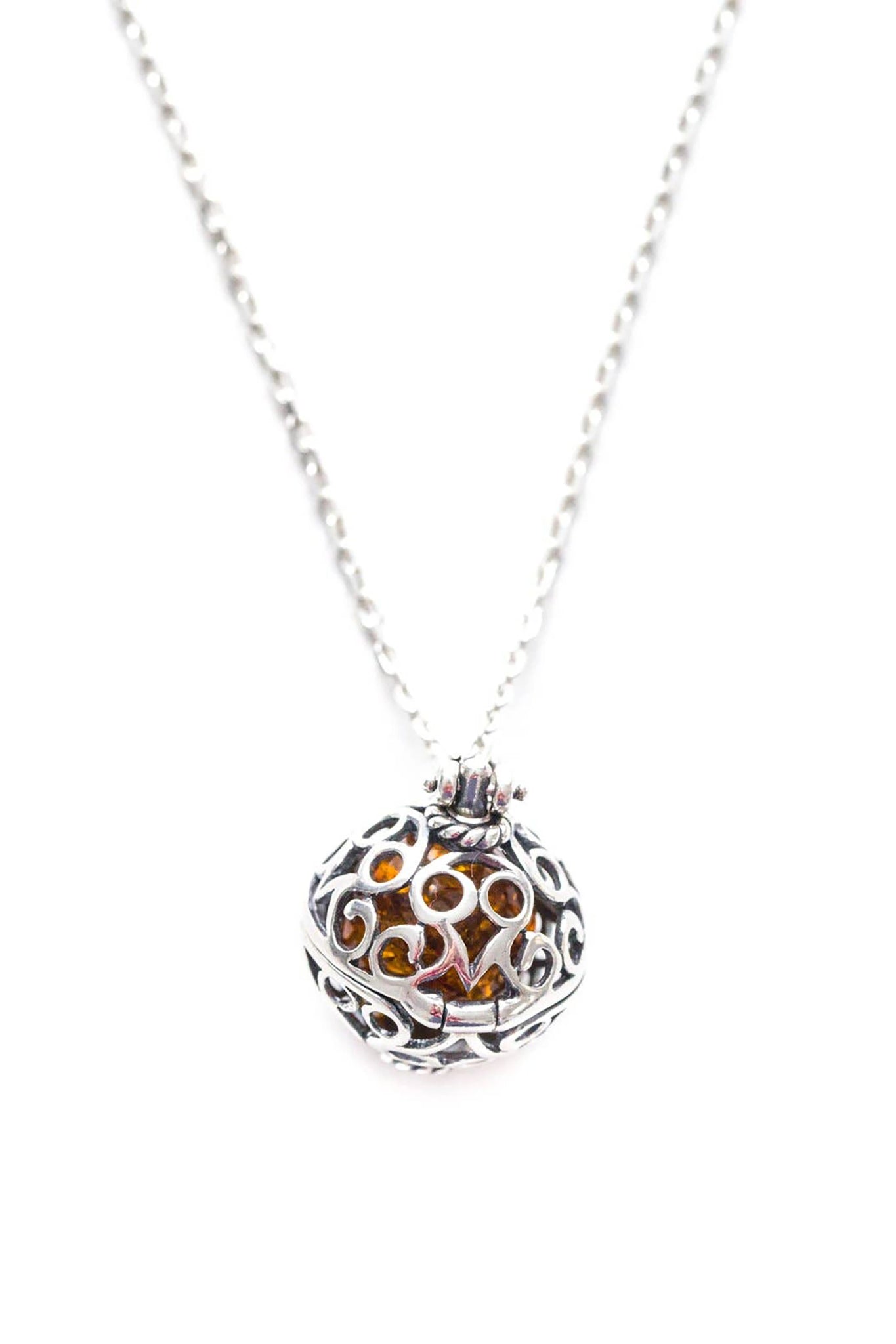 Baltic Honey Amber Sterling Silver Filigree Locket Necklace pendant is closed in front of a white background