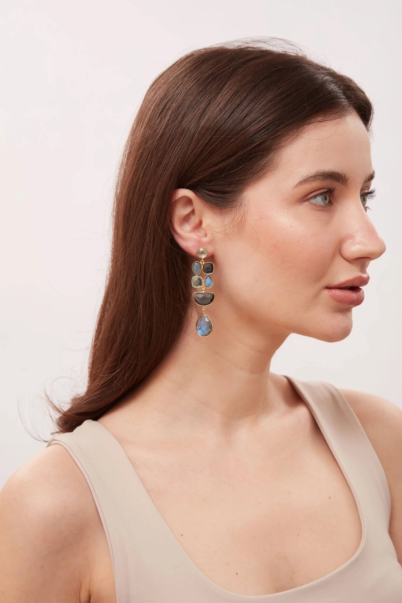Profile of a woman wearing earrings with a neutral background