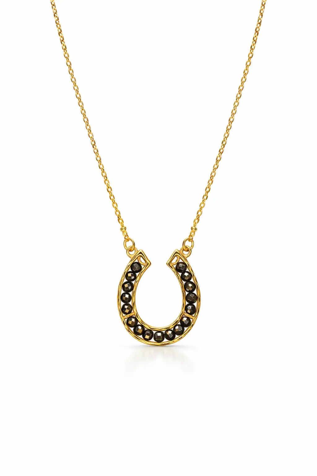 Gold necklace with pyrite stones on a horseshoe pendant on a white background