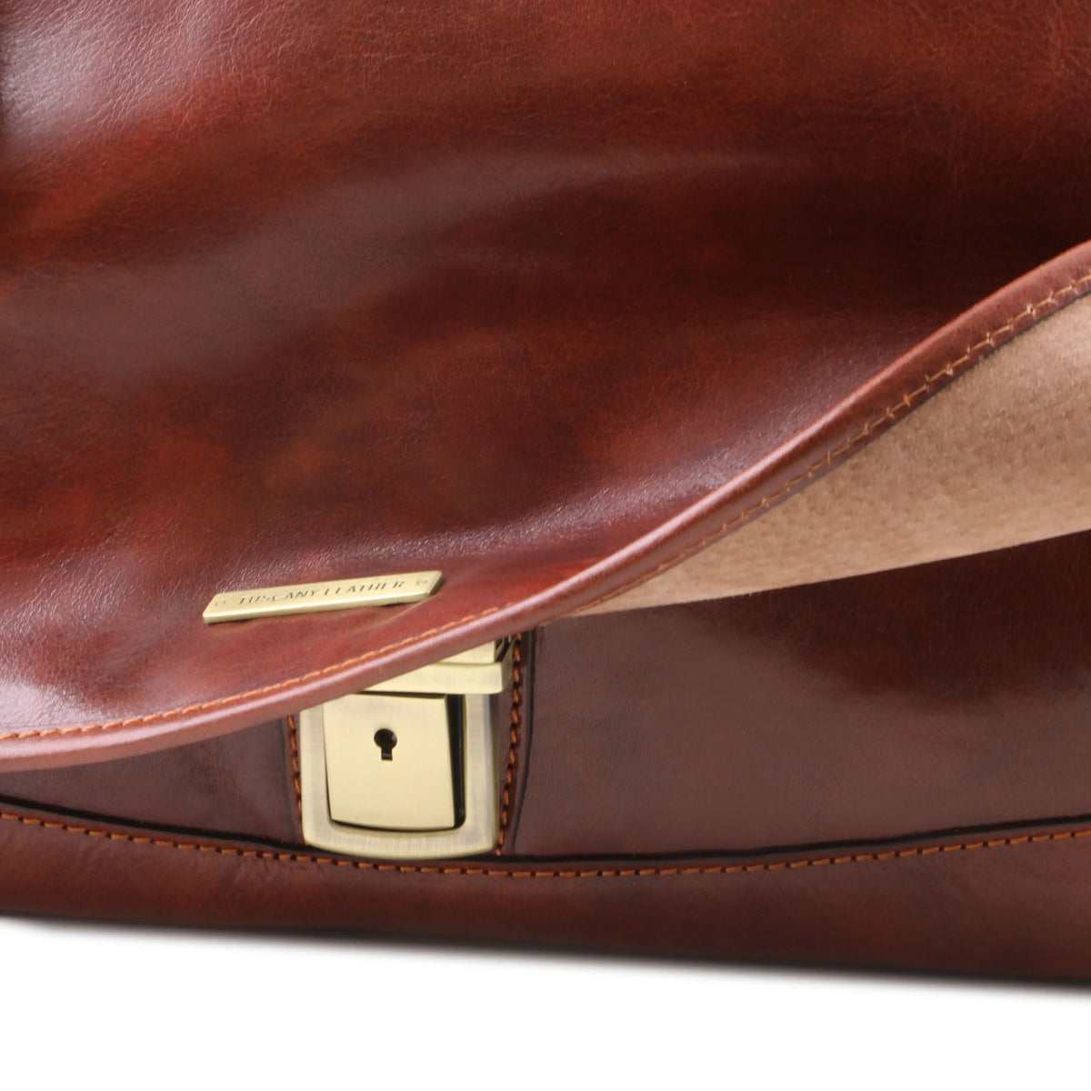 Close-up of a brown leather bag with a gold clasp on a white background