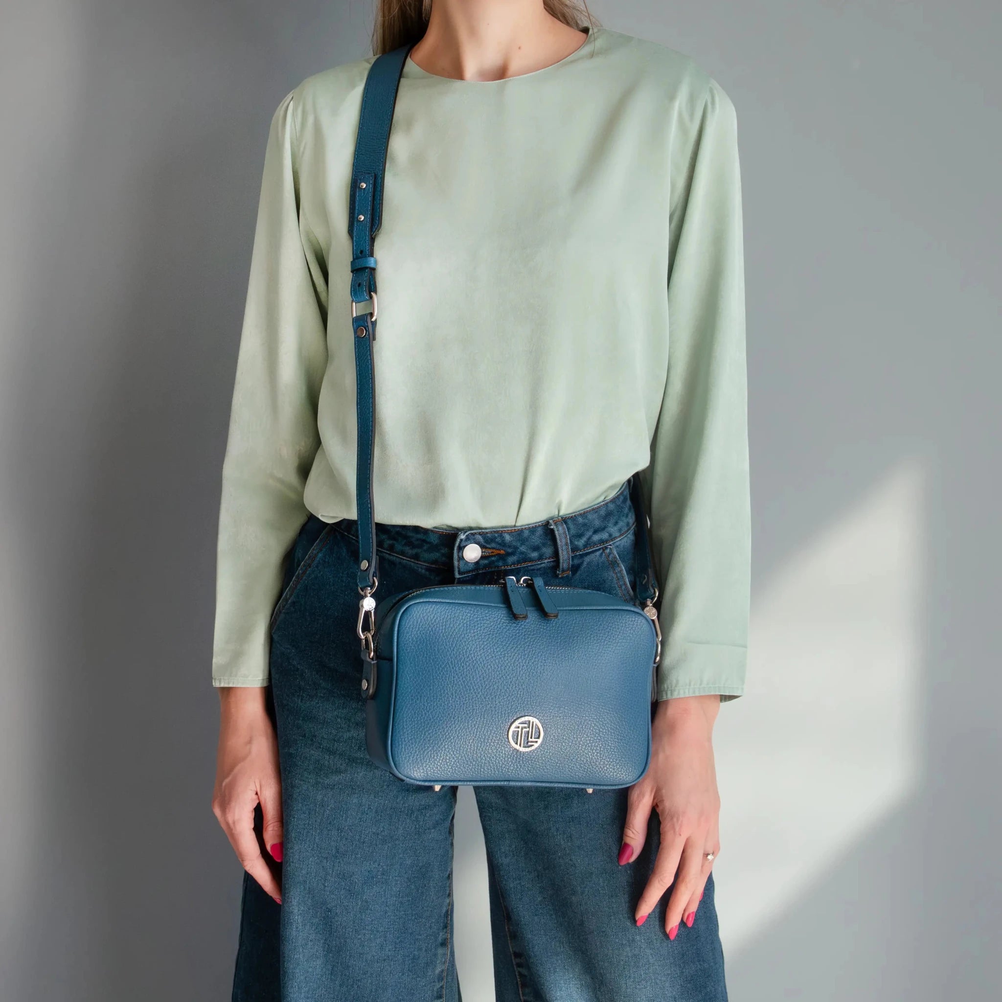 A woman carrying the Cubetto Italian Leather Shoulder Bag over her shoulder