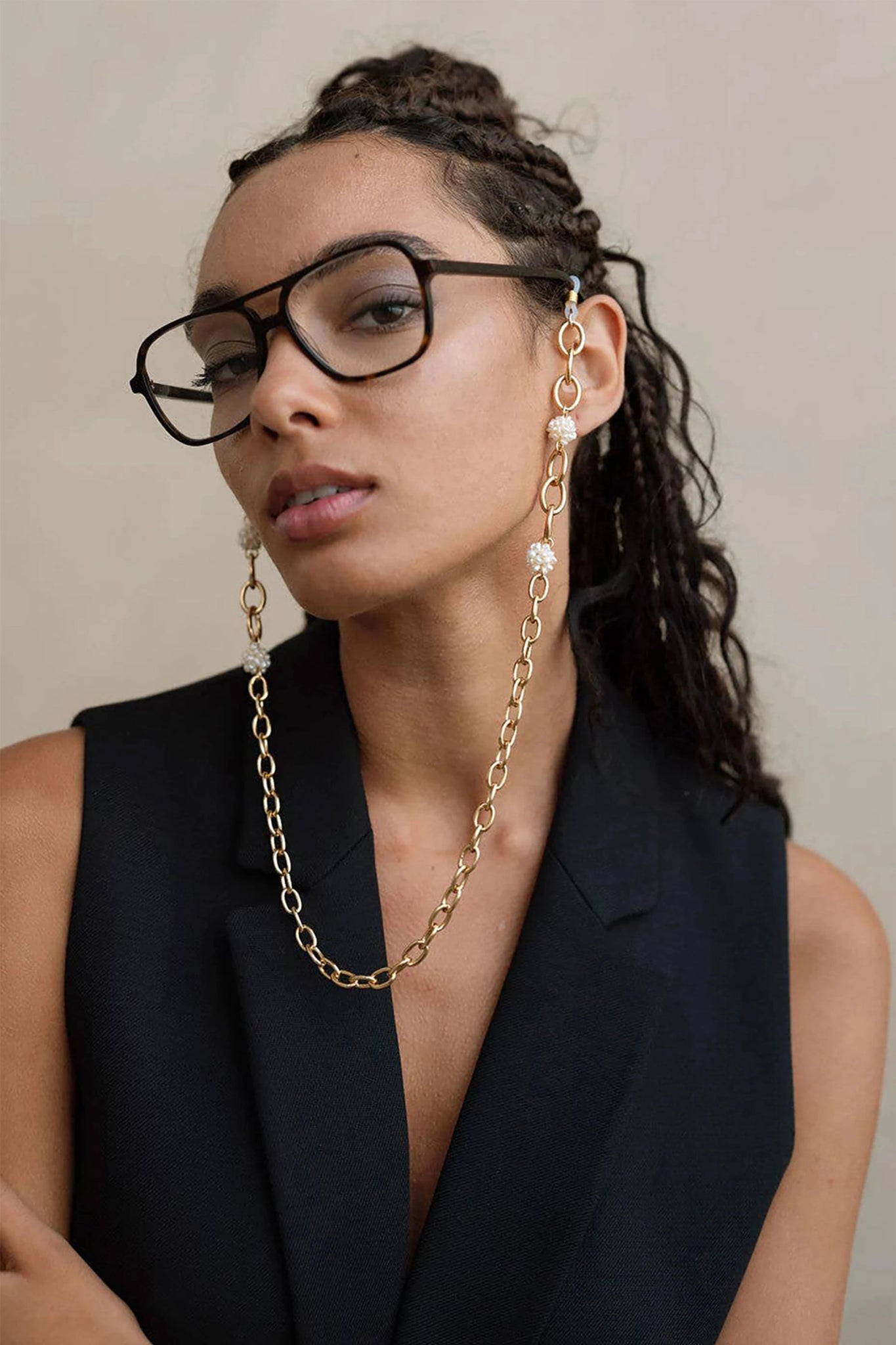 L'Atelier Global - A woman wearing our artisan-made French golden pearl eye glass chain.