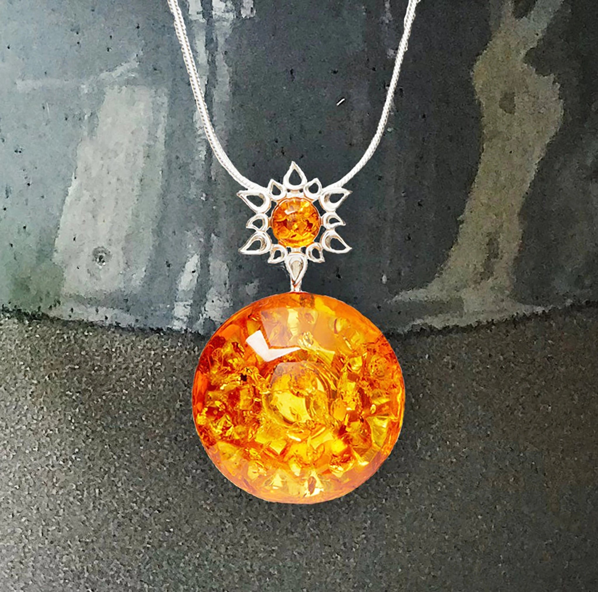 Honey Amber Star Necklace with silver chain on a gray ceramic background