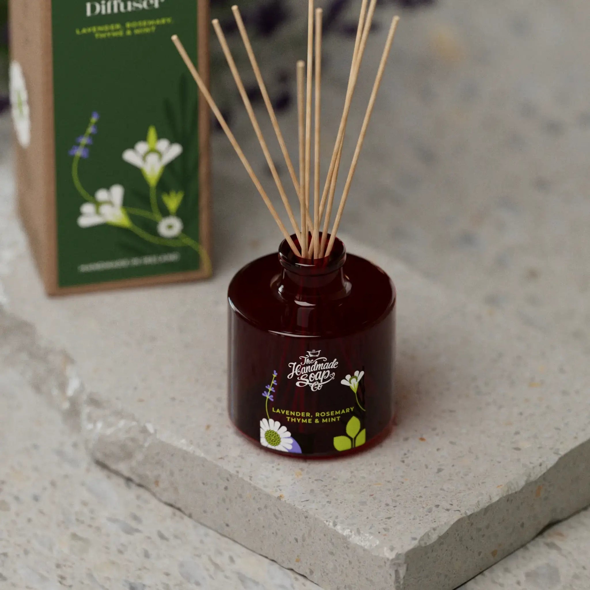 Brown diffuser with reeds and a box in the background on a stone surface