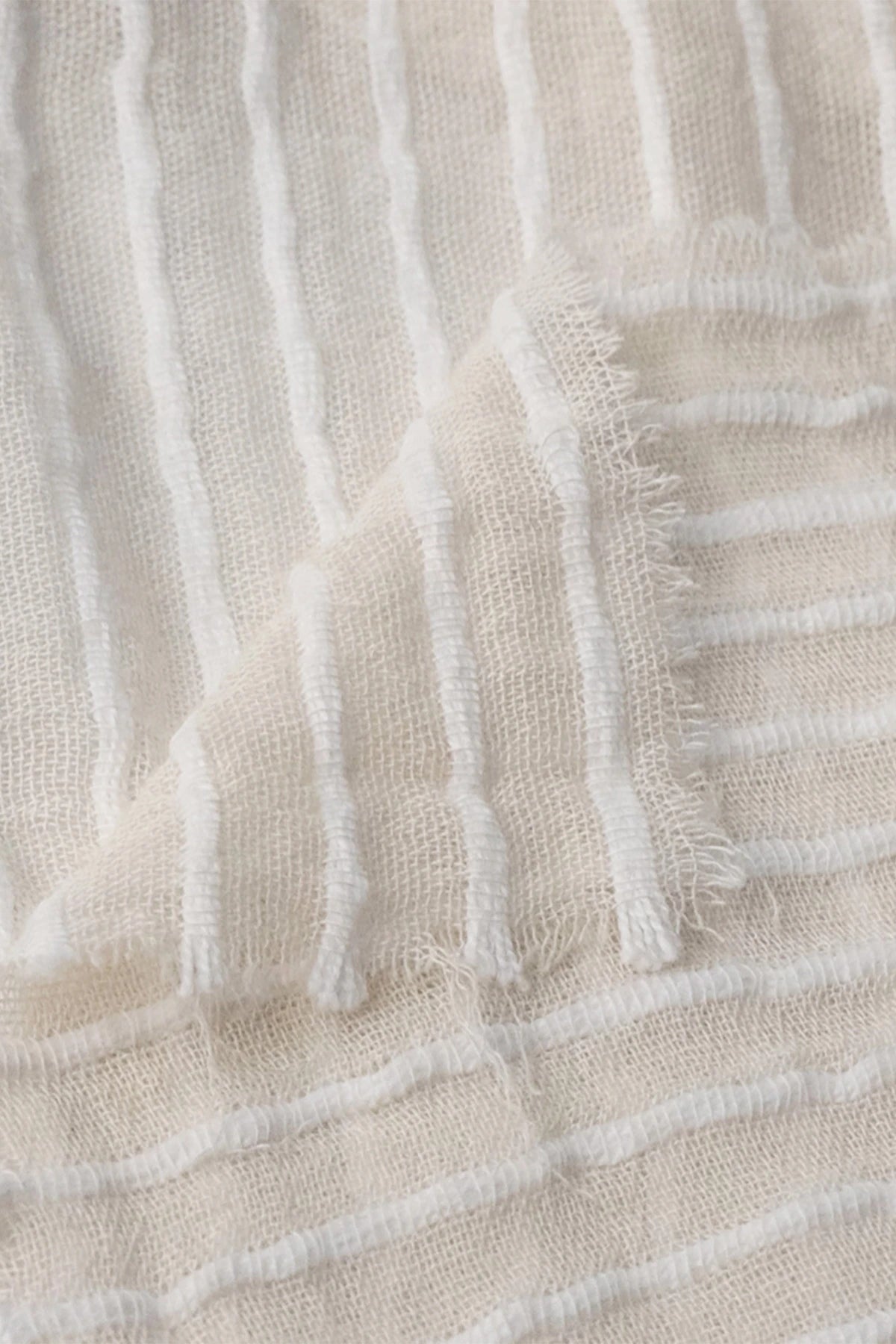 Close-up of textured beige fabric with white lines