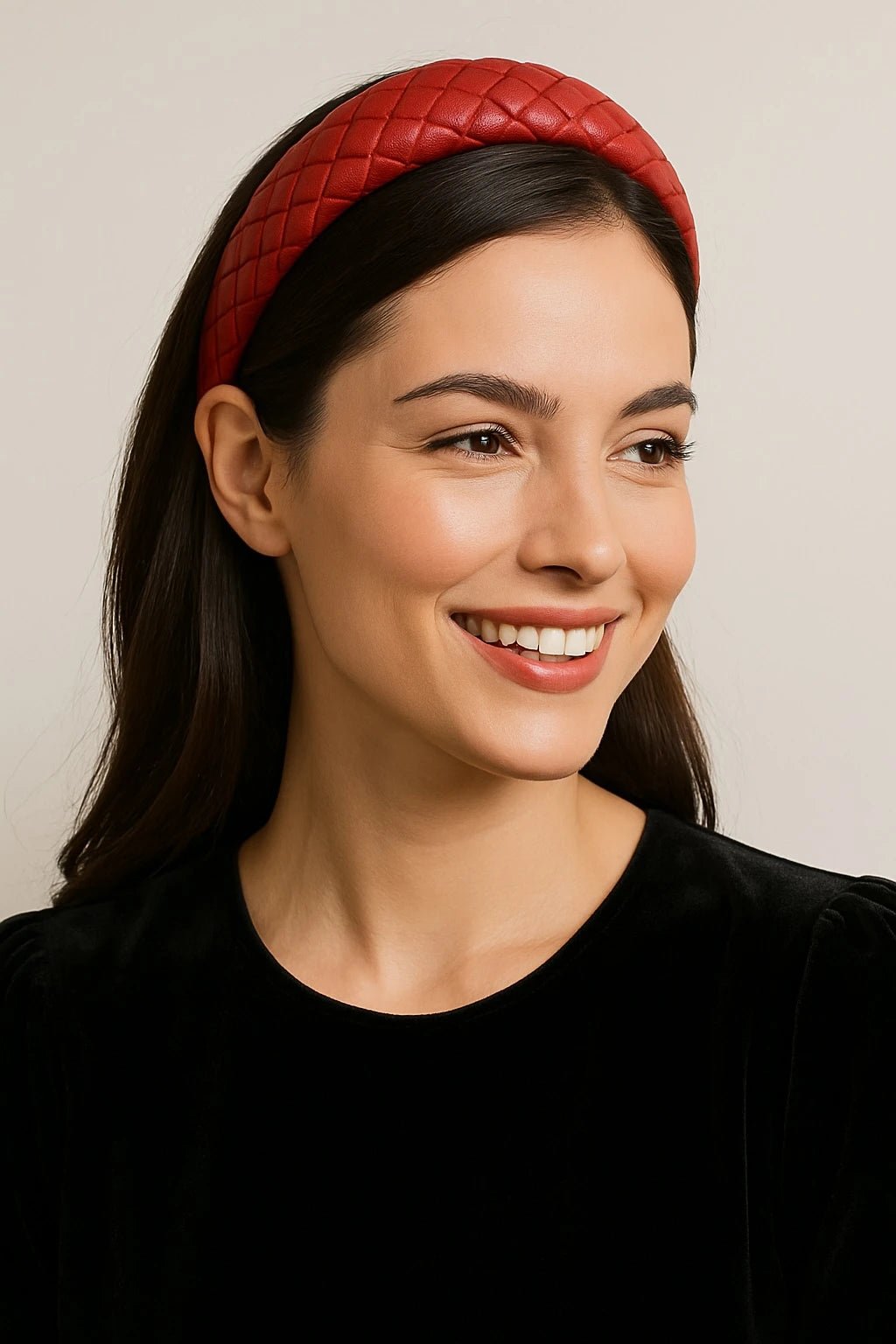 Woman wearing a red leather quilted headband against a neutral background
