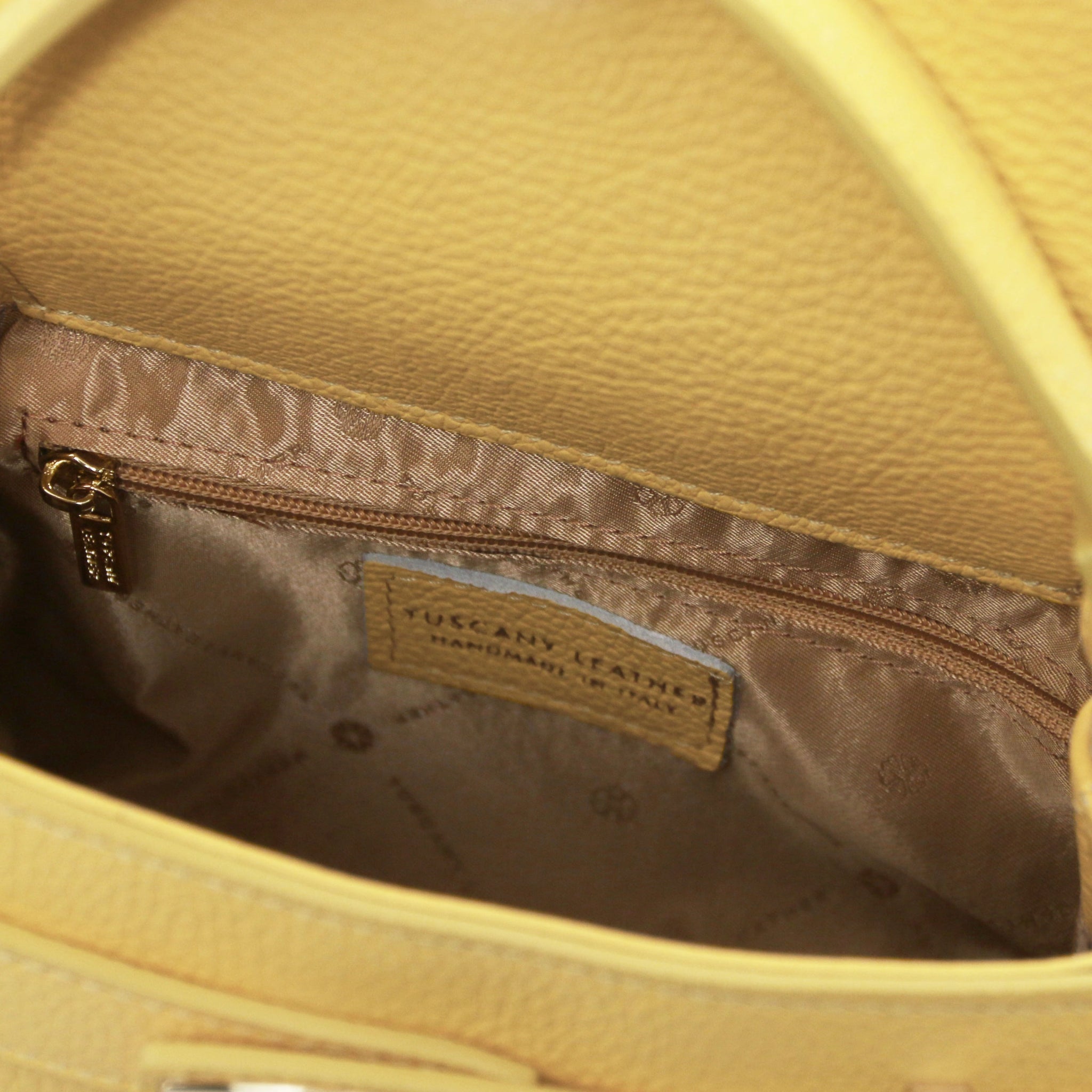 Interior zippered pocket view Maisy Italian Leather Tote Bag in Pastel Yellow showing the red bag lining