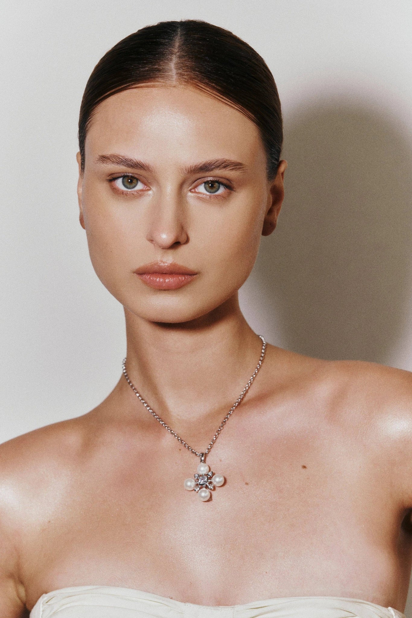 A woman wearing our MOP Gold cross pendant necklace.