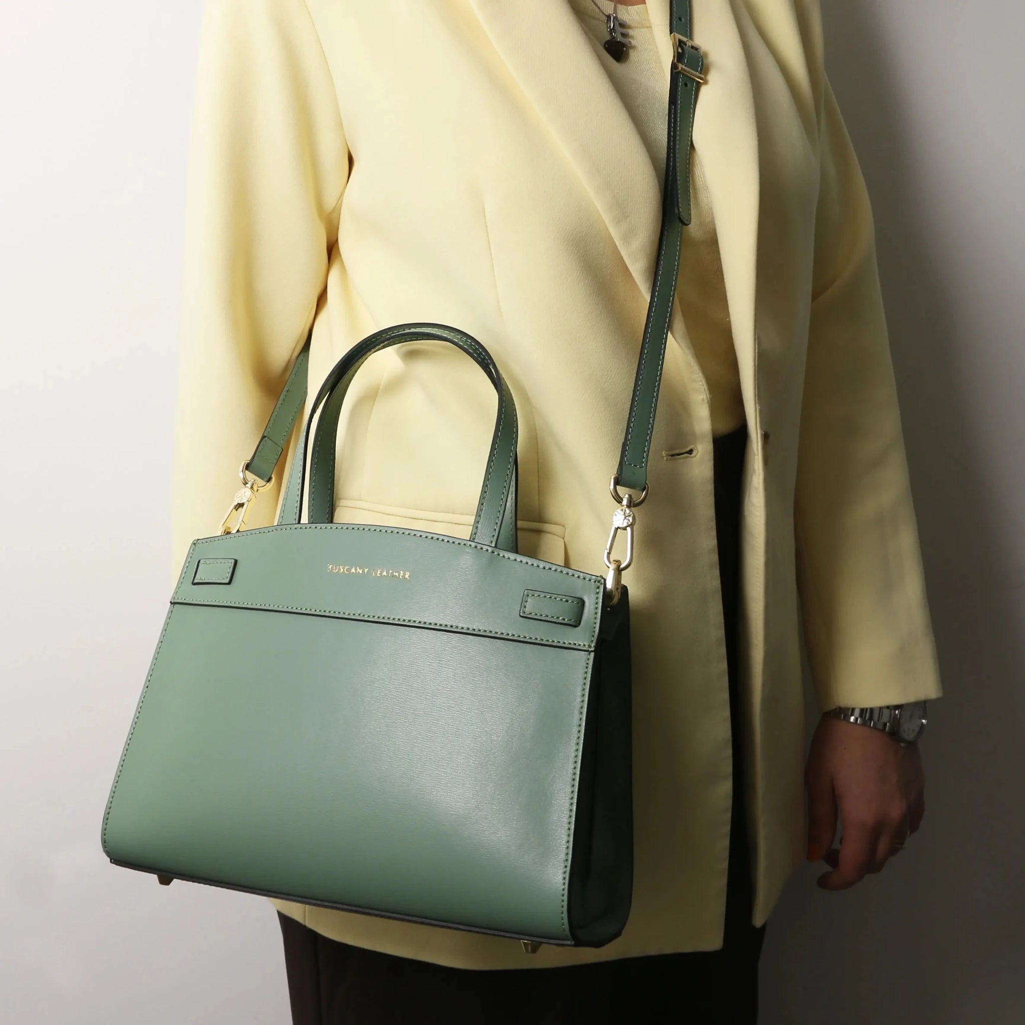 A woman is wearing the Musa Italian Smooth Leather Tote Bag in mint green as a cross body bag