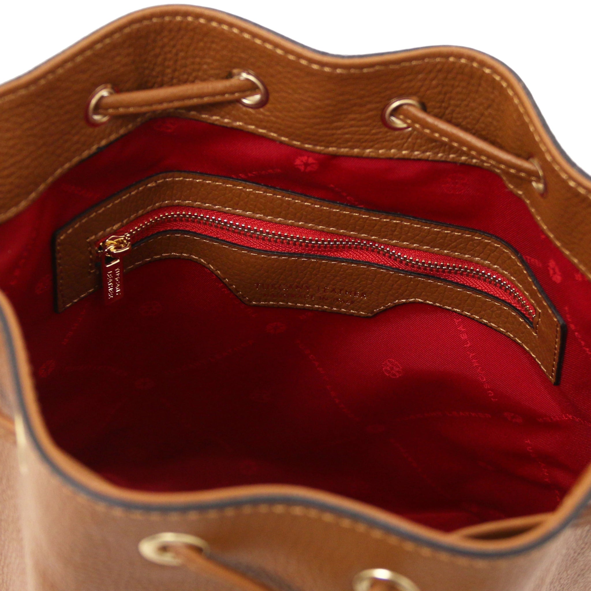 Interior view Panerea Leather Bucket Bag in Cognac showing interior zip pocket, drawstring with grommets and red lining