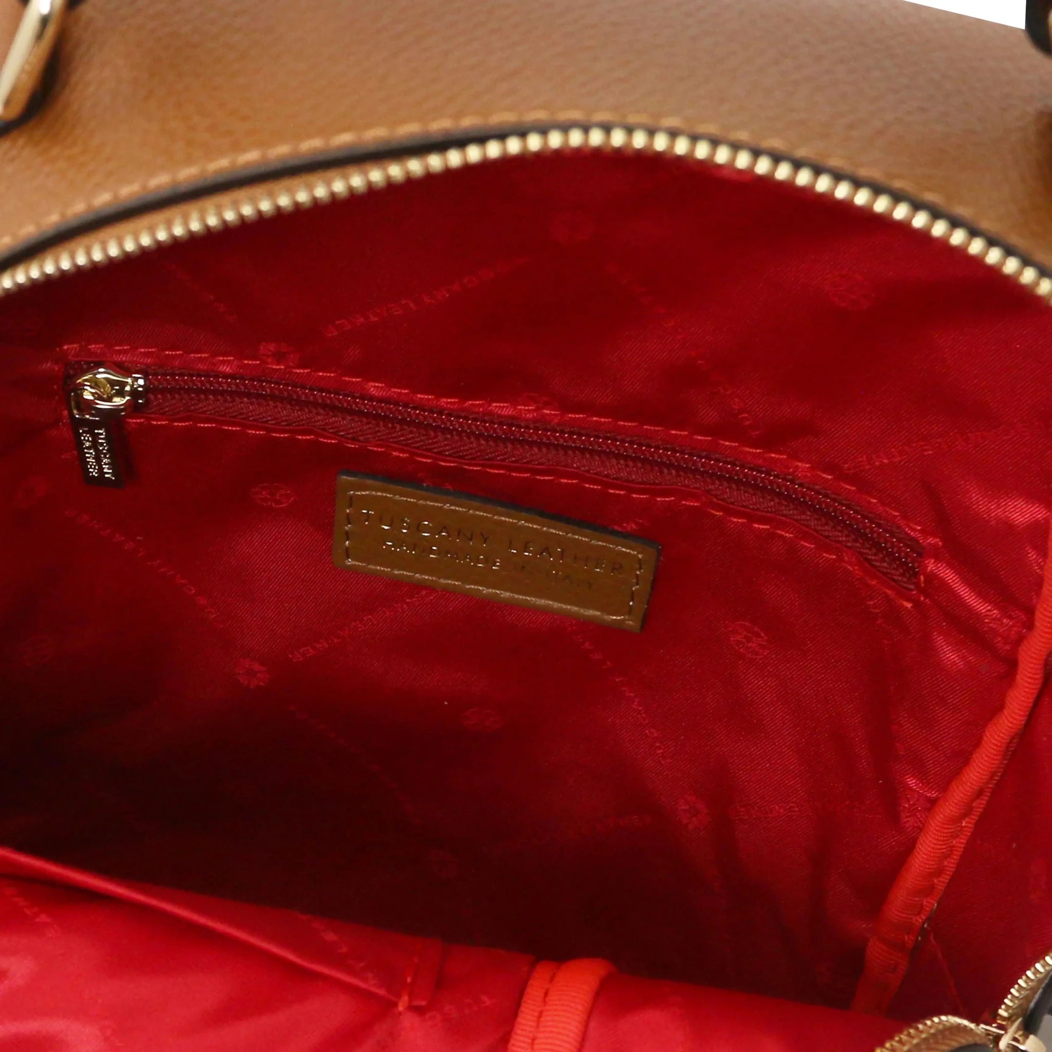 Interior zip pocket view Prisma Leather Backpack in cognac with red lining