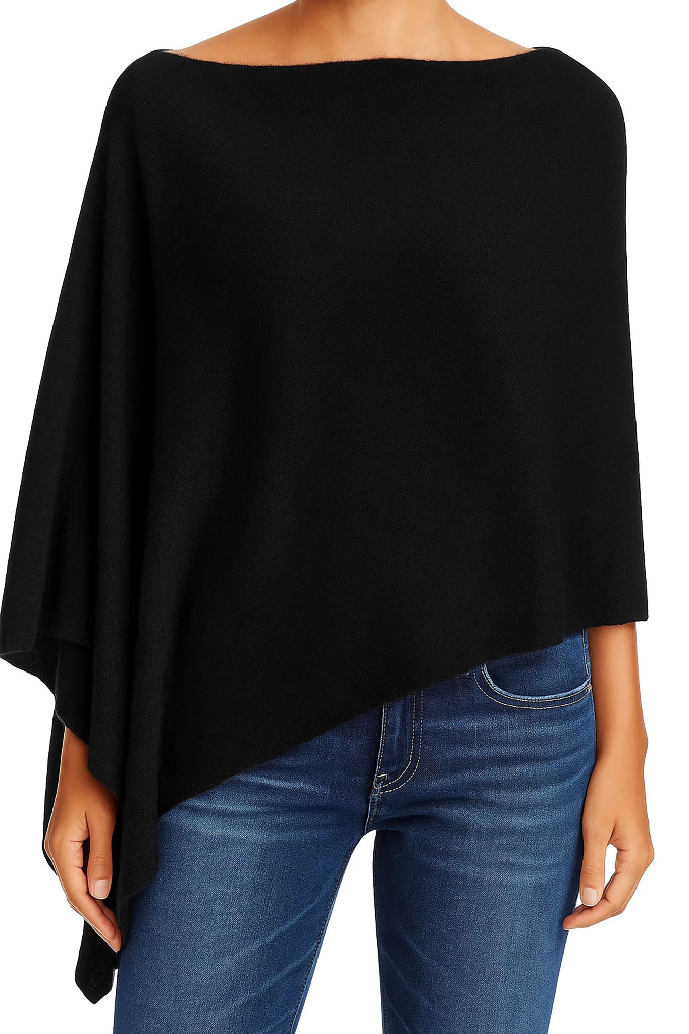 A model wearing the Ravello Cashmere Poncho in black on blue jeans