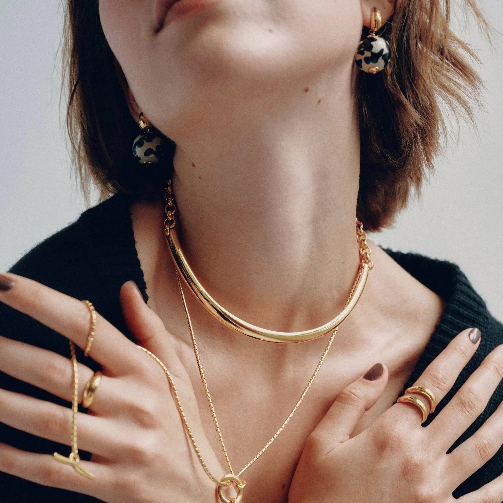 Close up front view of Golden Arc Collar Necklace on a woman's neck
