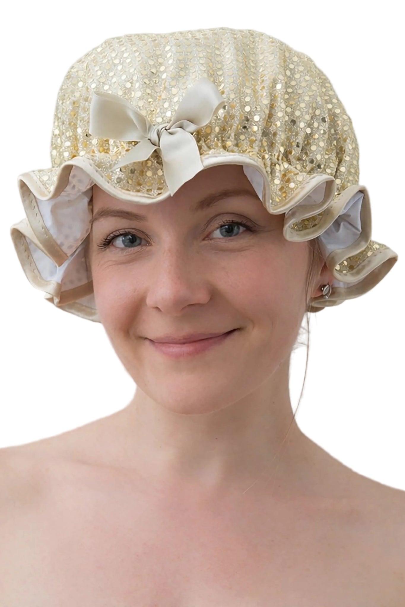 Woman wearing a gold sequin bonnet with ruffles and bows on a plain background