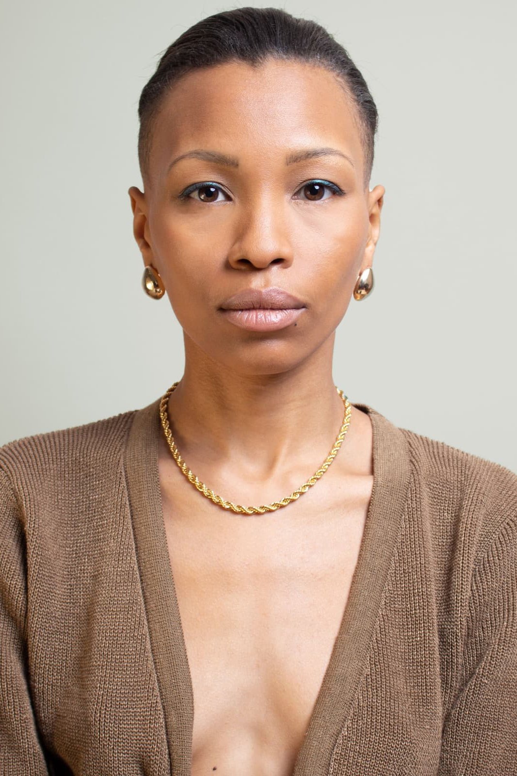 Textured Rope Chain Necklace in gold on model wearing a brown v-neck dress 