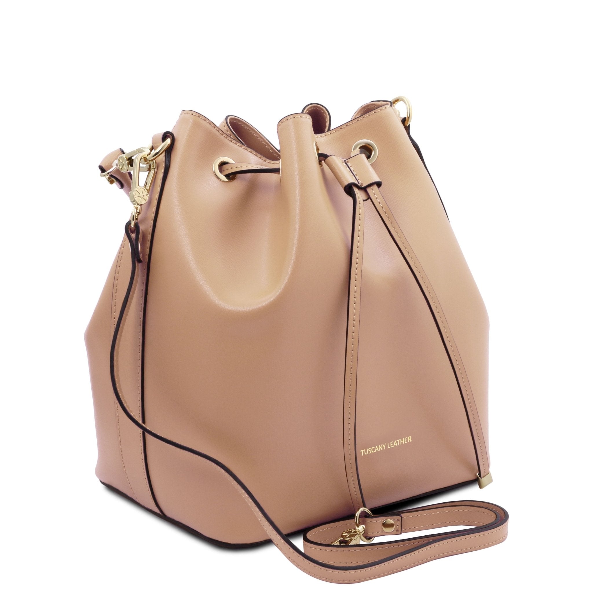 Side view of Vittoria Leather Bucket Bag in champagne with removable shoulder strap on a red background - L'Atelier Global