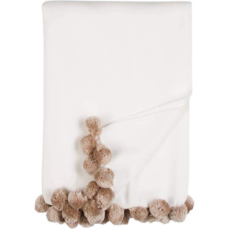 Bamboo Luxxe Pom Pom Throw in white with camel pom poms folded on a white background - L'Atelier Global