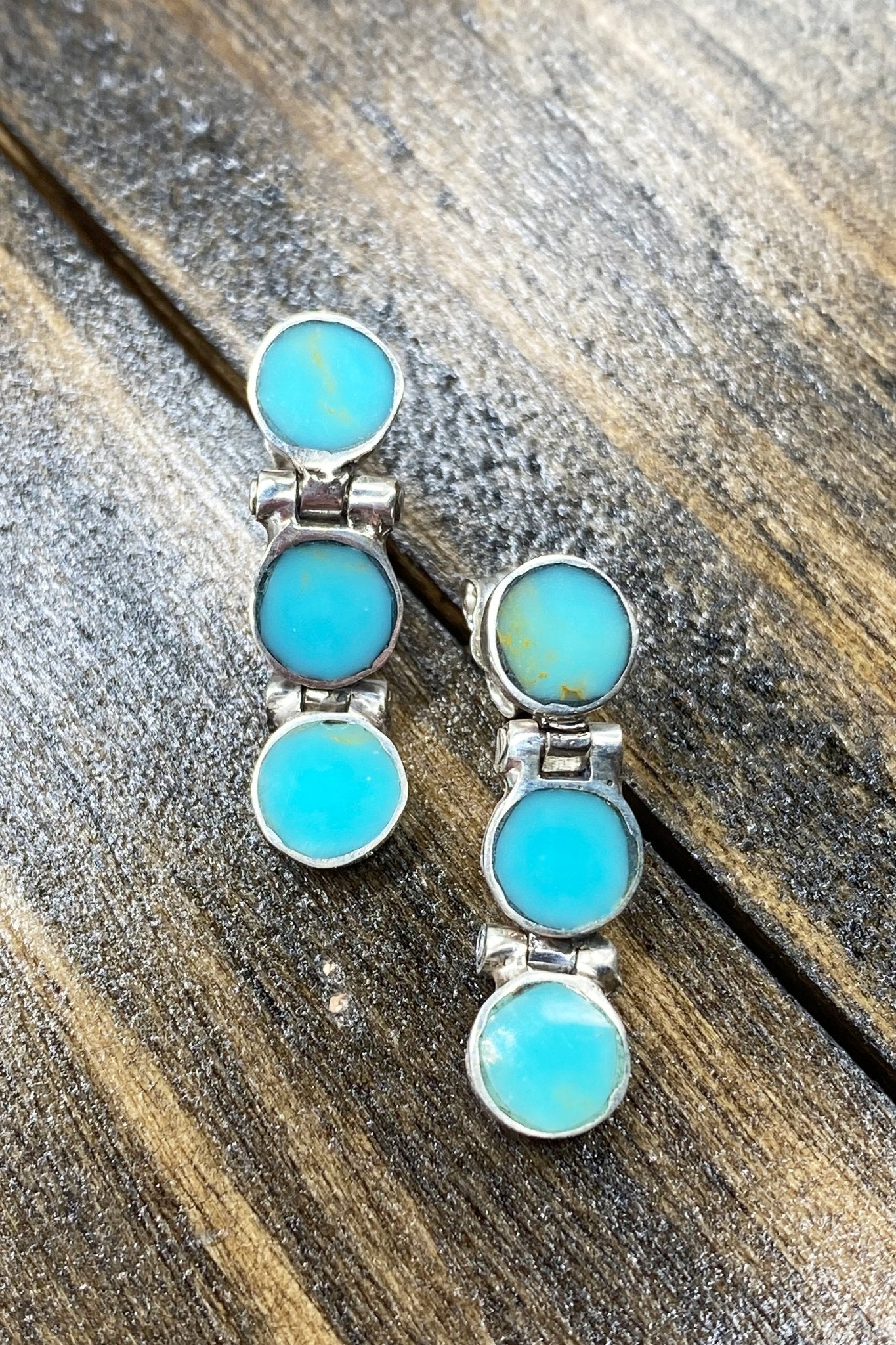 Chilean Turquoise Round Drop Earrings laying on a wooden table - L'Atelier Global