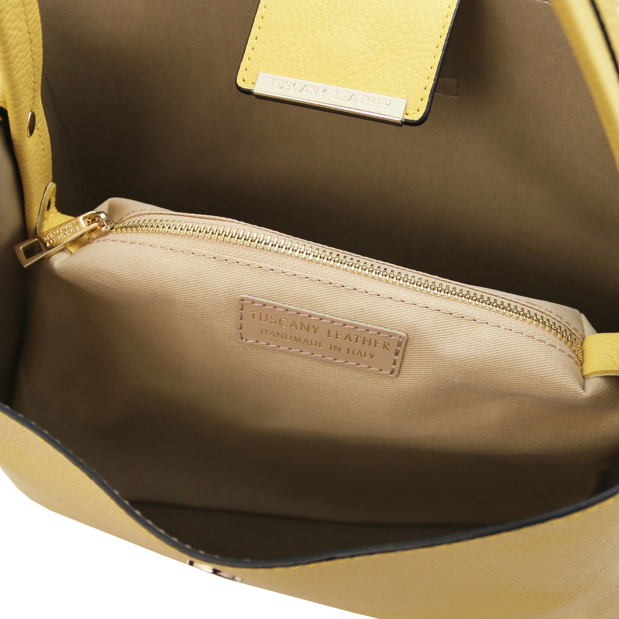 Interior central zippered compartment and light tan lining view of the Clio Italian Pebbled Leather Secchiello Bag in Pastel Yellow