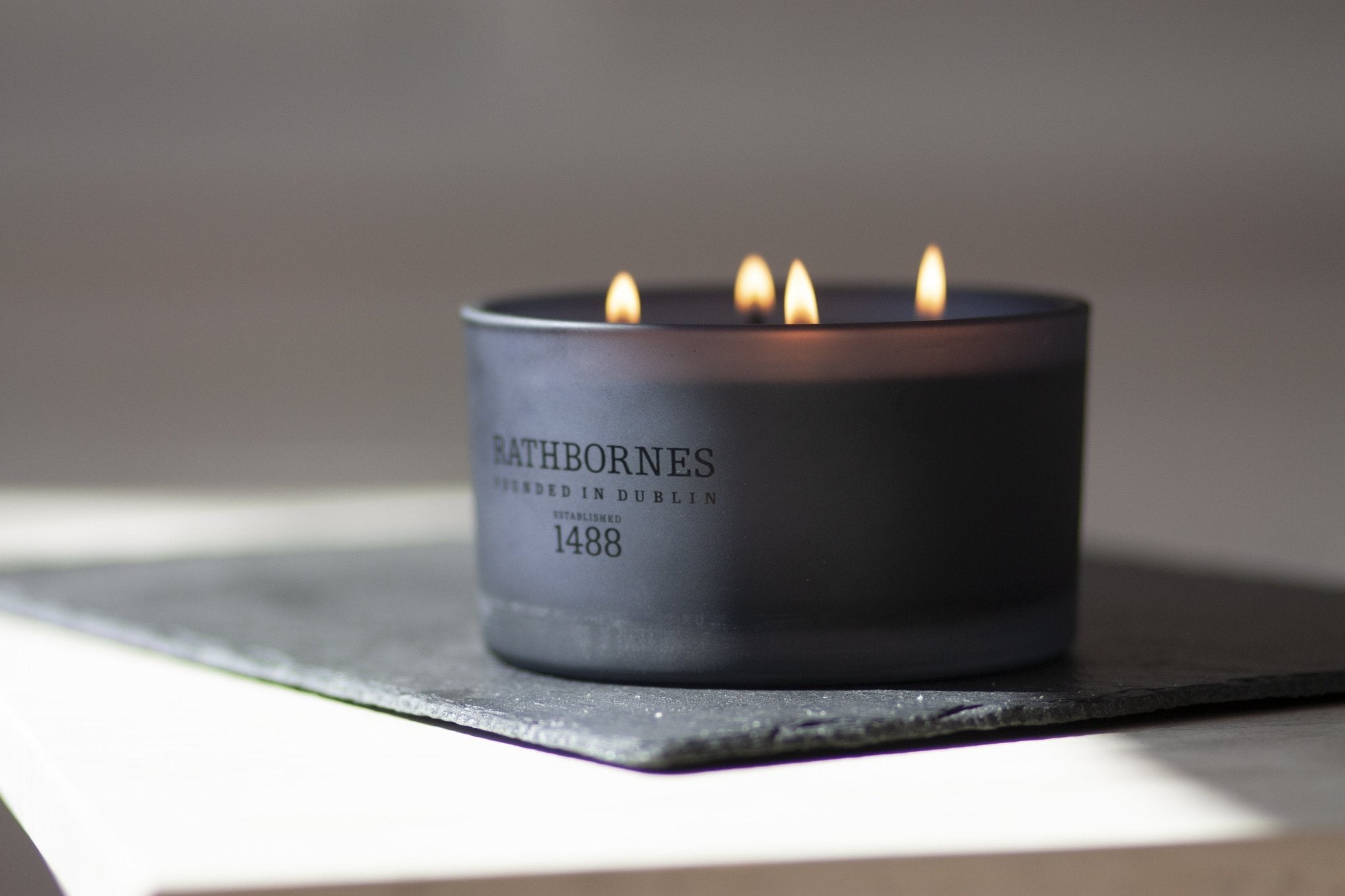 Dublin Dusk Luxury Beeswax Candle lit on a table - L'Atelier Global