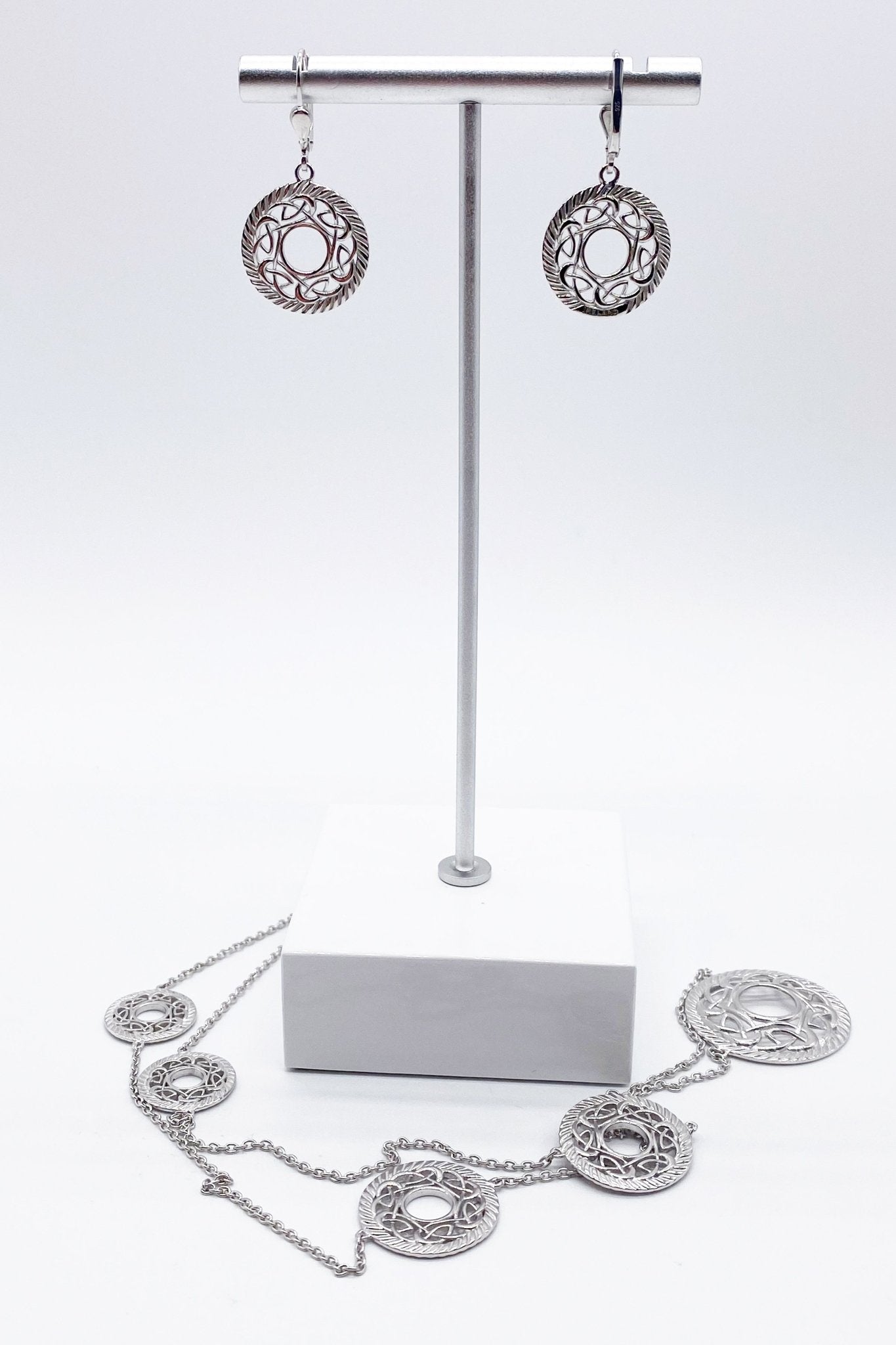 Everlasting Love Sterling Silver Necklace and matching earrings on a jewelry stand with a white marble base- L'Atelier Global