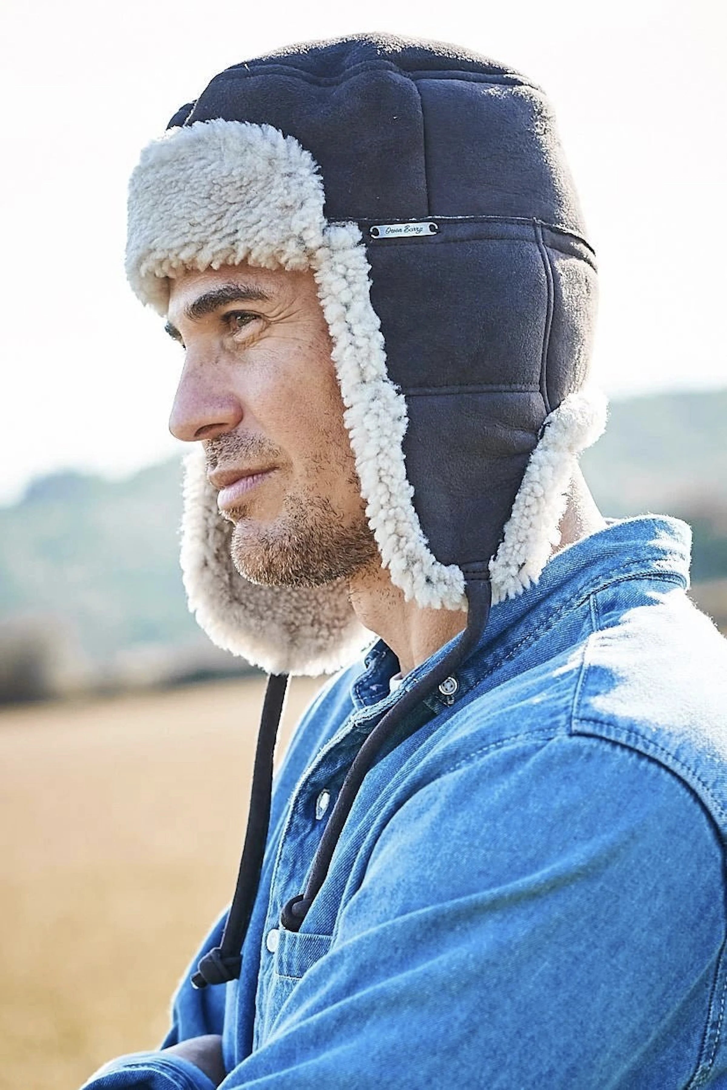 Kent Classic Sheepskin Trapper Hat in Dark Brown on a male model wearing a denim shirt- L'Atelier Global