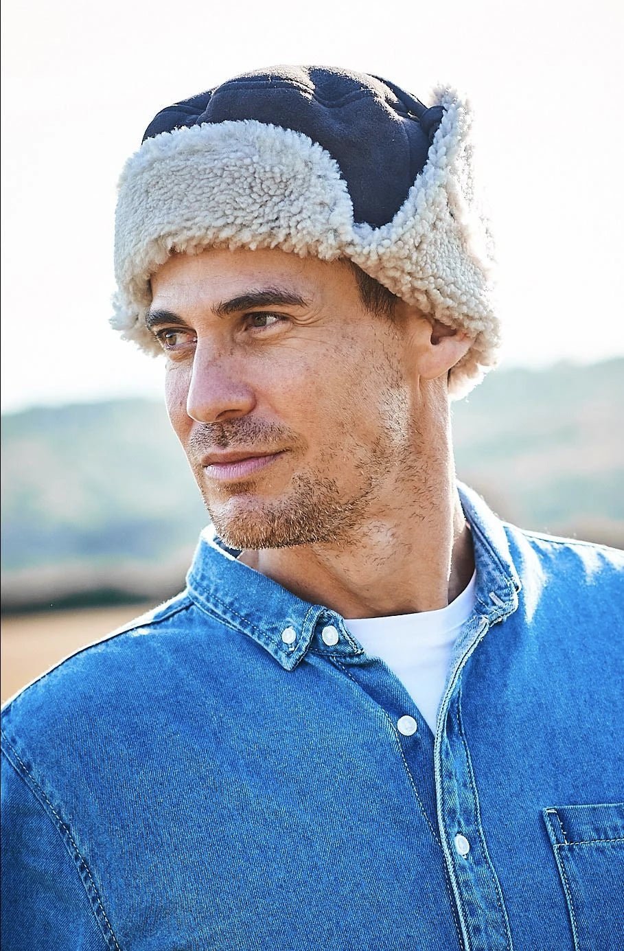 Kent Classic Sheepskin Trapper Hat, flaps are all pulled up, Dark Brown on a male model wearing denim shirt- L'Atelier Global