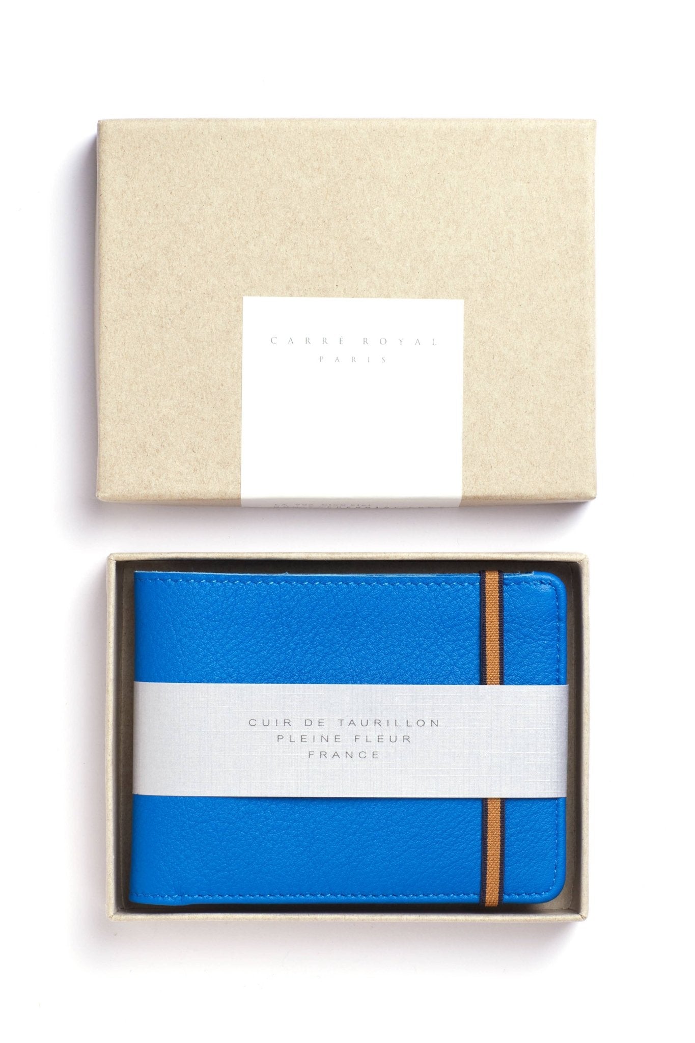 Light Blue Minimalist Wallet with orange elastic closure and box on a white background - L'Atelier Global