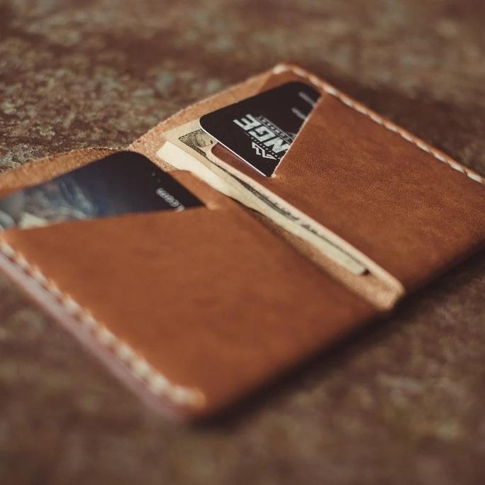 Minimalist Horween Wallet in natural opened displaying its card pockets on a wood table- L'Atelier Global