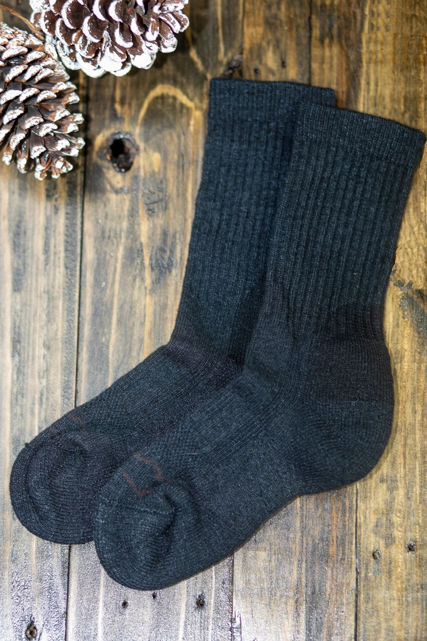 The American Bison Wool Everyday Silk Blend Crew Sock on wooden table, snowy pinecone on top left corner - L'Atelier Global