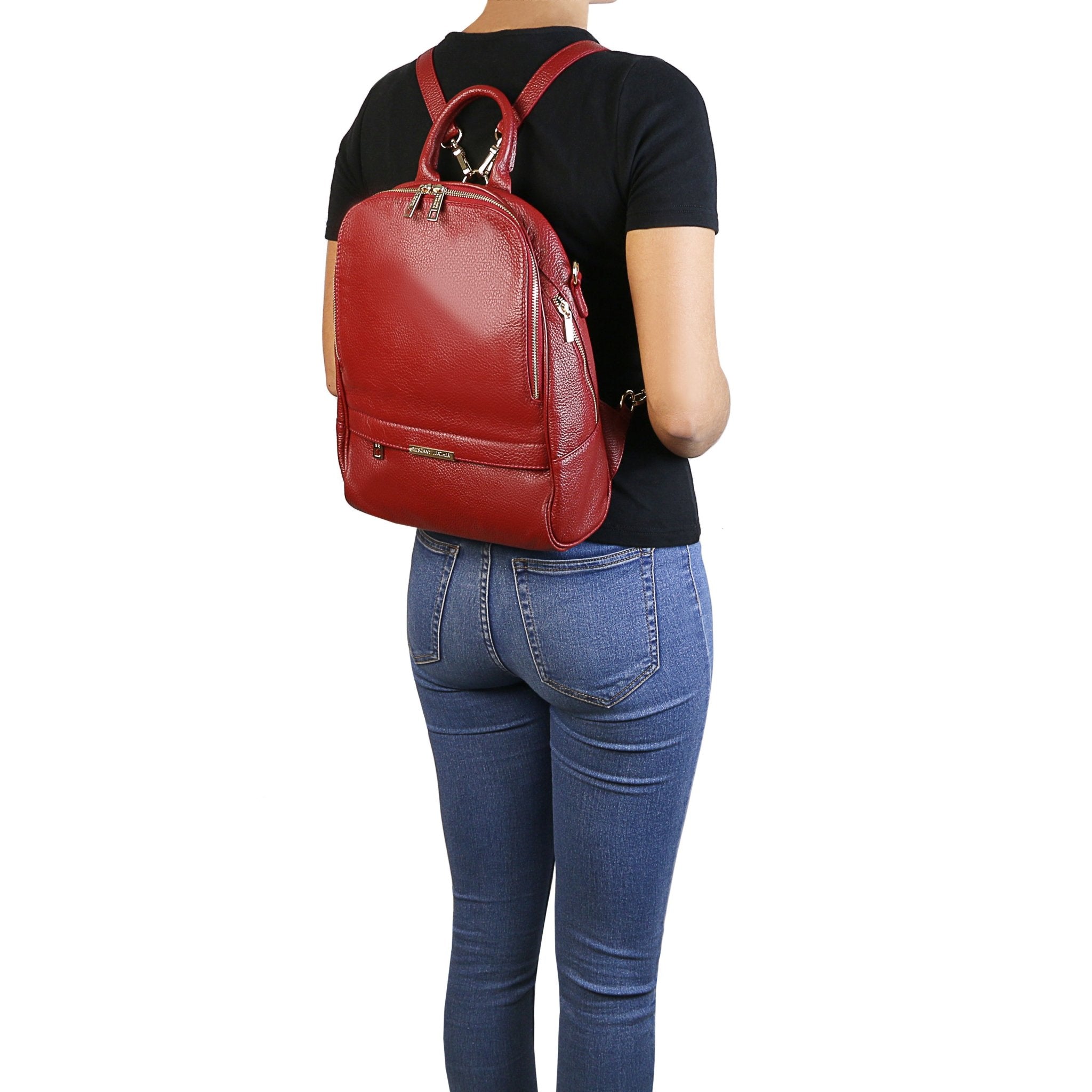 Model wearing black shirt and blue jeans wearing TL Bag Soft Leather Backpack in red on white background - L'Atelier Global