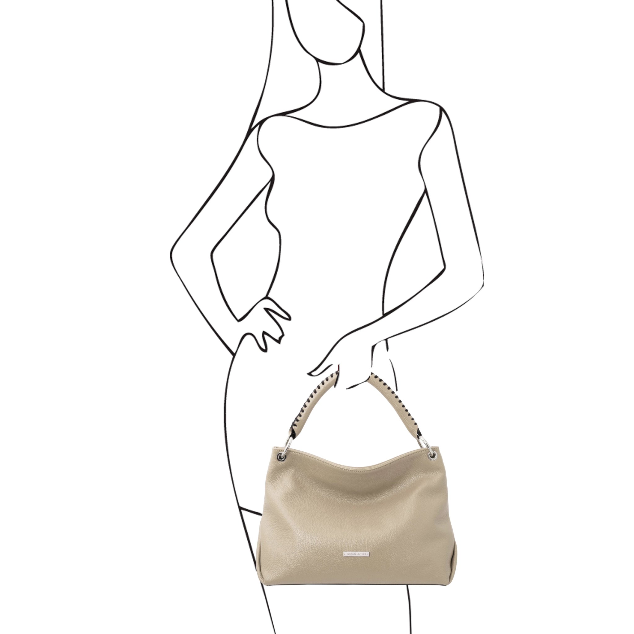 A sketch of a female model holding the TL Bag Soft Leather Handbag in Beige on a white background - L'Atelier Global