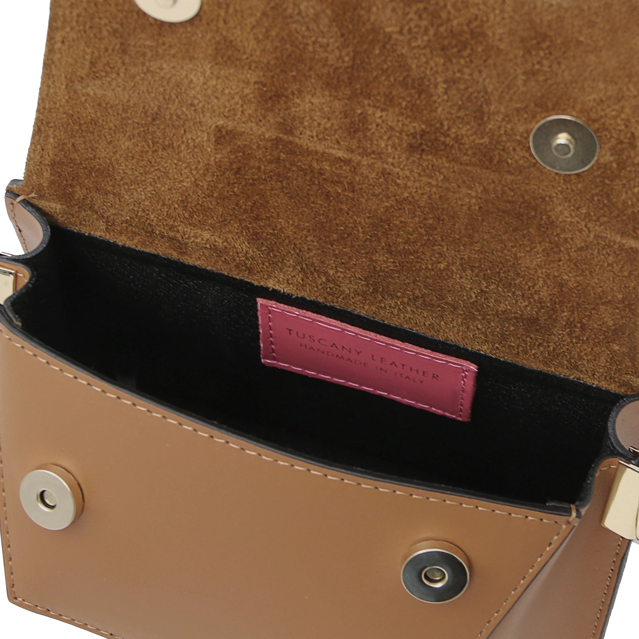 Interior view TL Leather Assymetrical Shoulder Bag  in Cognac showing Tuscany Leather branding  and magnetic button closures