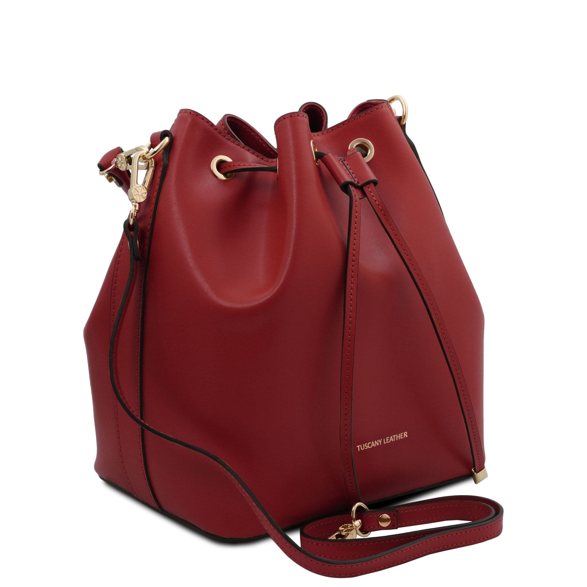 Side view of Vittoria Leather Bucket Bag in black with removable shoulder strap on a red background - L'Atelier Global