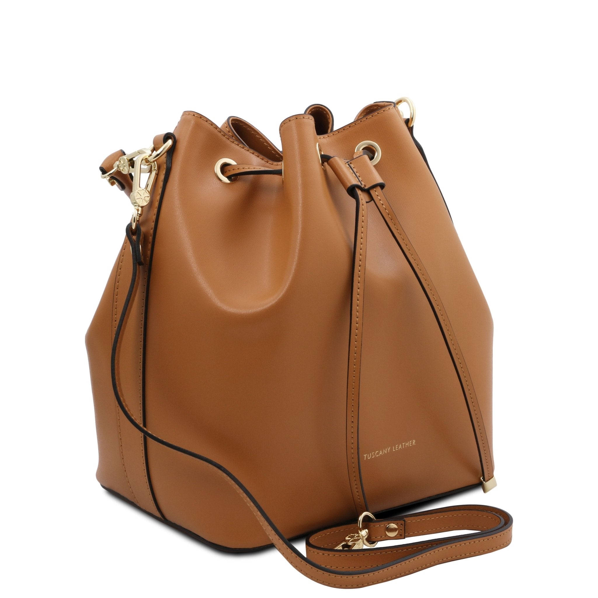 Side view of Vittoria Leather Bucket Bag in cognac with removable shoulder strap on a red background - L'Atelier Global