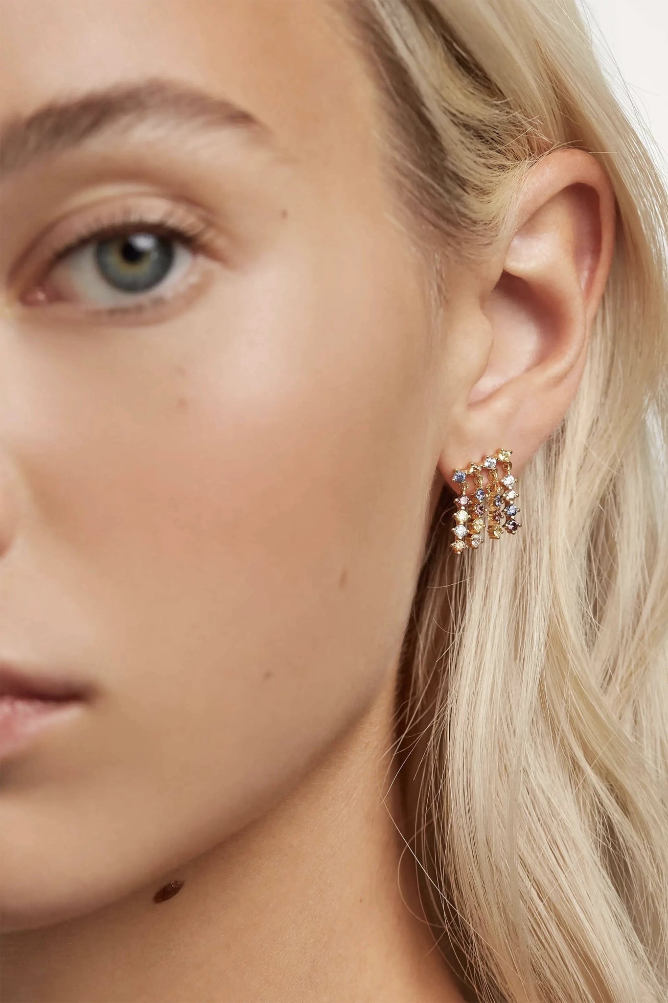 Left profile of a long blonde haired female model wearing the Willow Gold Dangle Earrings - L'Atelier Global