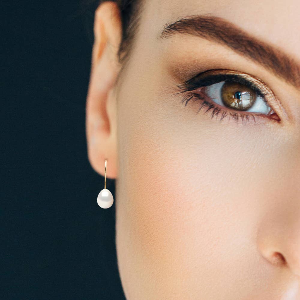 Yellow Gold Freshwater Pearl Pendant Earrings on a model showing her right ear. 